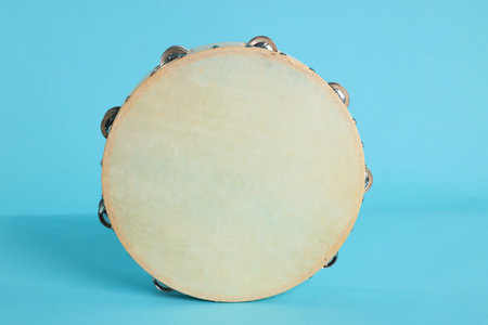Tambourine on light blue background. Traditional musical instrumentの写真素材