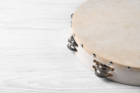Tambourine on white wooden background, closeup. Space for textの写真素材