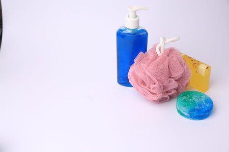 Pink shower puff and cosmetic products on white background, space for text