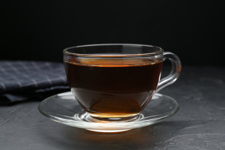 Aromatic tea in glass cup on black table, closeupの写真素材