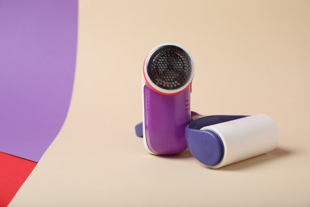 Lint roller and fabric shaver on color background, space for textの写真素材