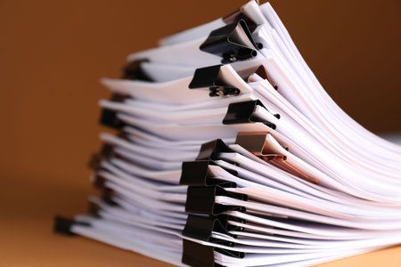 Many documents with binder clips on brown background, closeupの写真素材