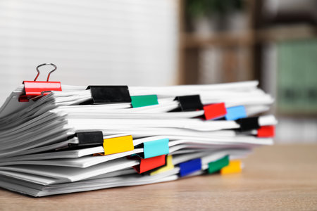 Stack of documents with binder clips on wooden table indoors, closeupの写真素材