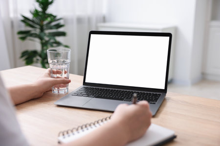 Woman working with laptop at wooden table indoors, closeup. Mockup for designの写真素材