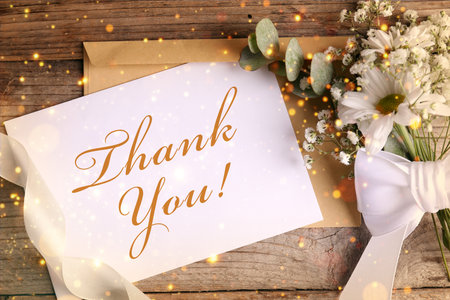 Thank you card, envelope and flowers on wooden background, top view. Bokeh lightsの写真素材