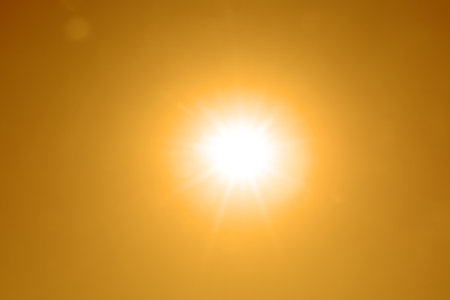 Bright sun in orange sky during hot summer weather.の写真素材