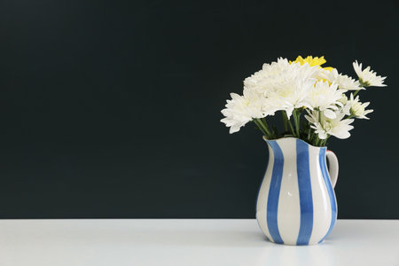 Happy teacher's day. Flowers on white table against chalkboard. Space for textの写真素材