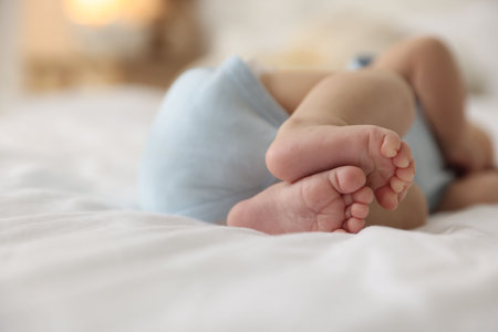Cute little baby lying on bed at home, closeupの写真素材