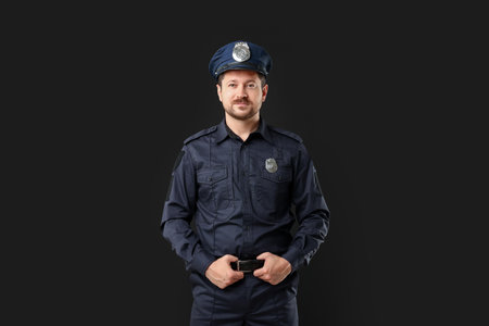 Policeman in uniform posing on black backgroundの写真素材