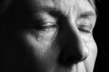 Senior woman crying on dark background, closeup. Black and white effectの写真素材