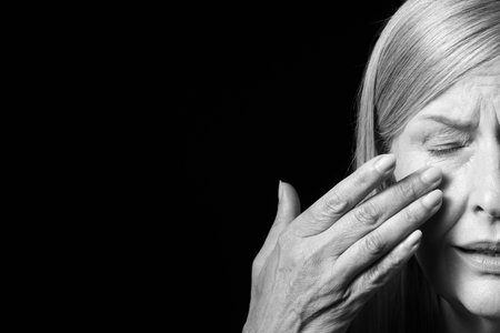 Senior woman crying on dark background, closeup. Black and white effectの写真素材
