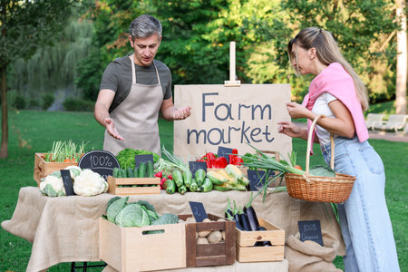 Woman choosing fresh vegetables from stall at farmer's marketの写真素材