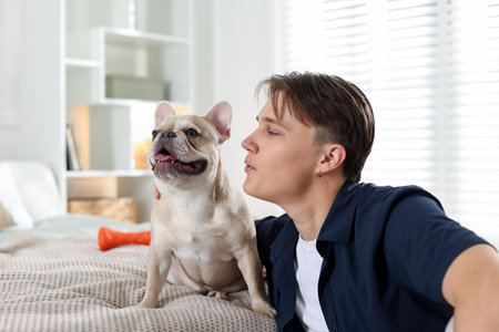 Man with his cute French bulldog at homeの写真素材