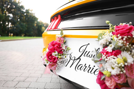 Wedding car. Cabriolet decorated with Just Married card and beautiful flowers outdoors, closeupの写真素材
