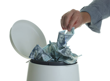 Person throwing money into trash bin on white background, closeupの写真素材