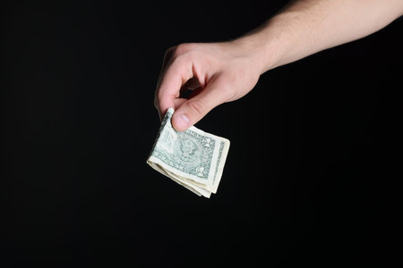 Man with dollar banknotes on black background, closeup