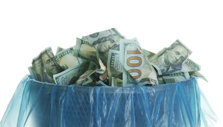 Trash bin with dollar banknotes isolated on whiteの写真素材