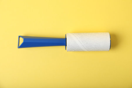 One lint roller on yellow background, top viewの写真素材