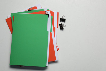 Many documents in folders with binder clips on light gray background, flat lay. Space for text
