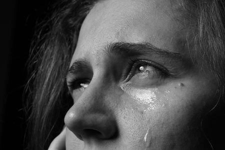 Sad woman crying on dark background, closeup. Black and white effectの写真素材