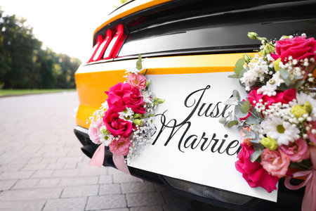 Wedding car. Cabriolet decorated with Just Married card and beautiful flowers outdoors, closeupの写真素材