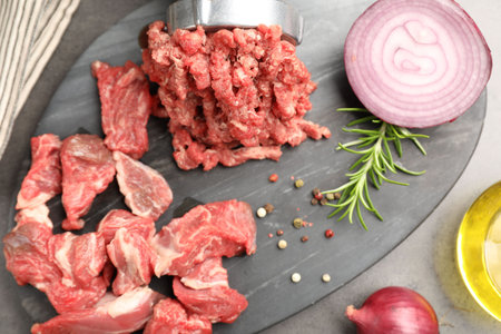 Making minced meat with grinder and spices on gray table, top viewの写真素材