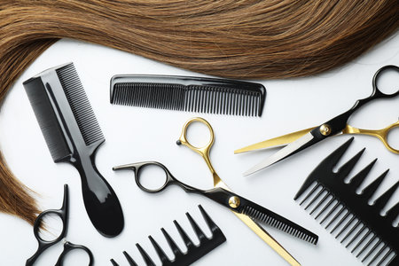 Beautiful hair strand and hairdresser's tools on white background, flat layの写真素材