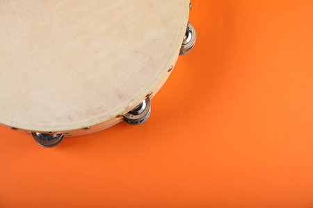 Tambourine on orange background, closeup. Space for textの写真素材