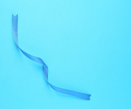 Beautiful ribbon on light blue background, top view. Space for textの写真素材