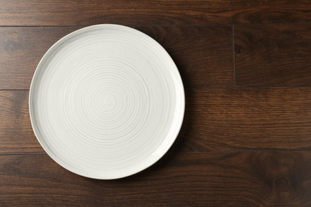 Empty ceramic plate on wooden table, top view. Space for textの写真素材