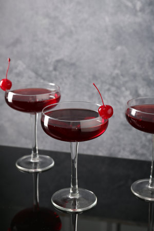 Glasses of tasty cocktails with garnish on mirror surface, closeupの写真素材