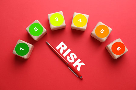 Level of risk. Pen pointing at cube with 2 on red background, top viewの写真素材
