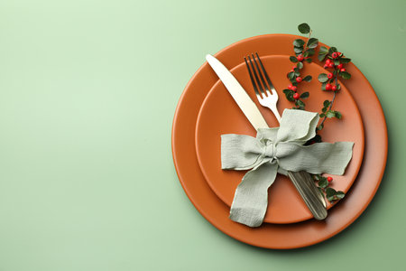 Beautiful table setting with autumn decor on green background, top view. Space for textの写真素材