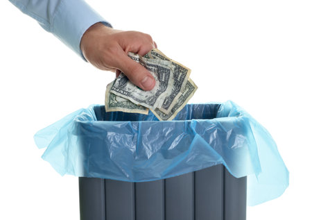 Man throwing money into trash bin on white background, closeupの写真素材