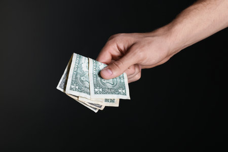Man with dollar banknotes on black background, closeupの写真素材