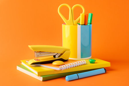 Stapler and other stationery on orange backgroundの写真素材