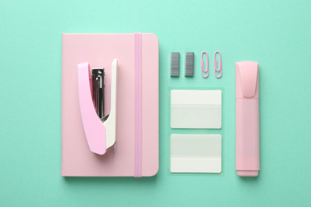 Stapler and other stationery on turquoise background, flat layの写真素材