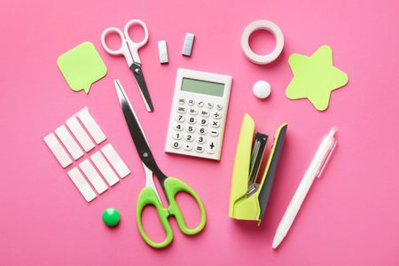 Stapler and other stationery on pink background, flat layの写真素材