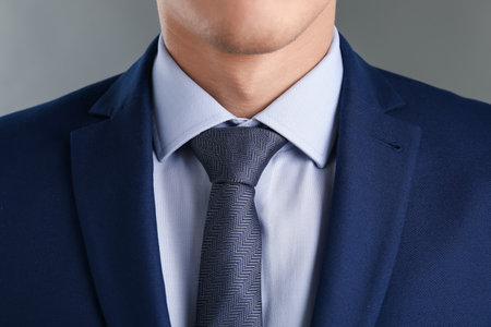 Man in suit with stylish necktie on gray background, closeupの写真素材