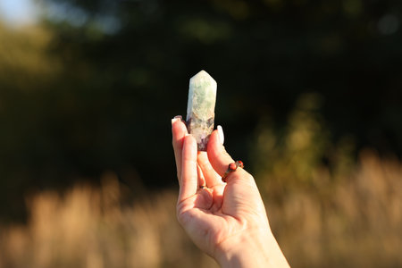 Woman meditating with crystal outdoors, closeupの写真素材