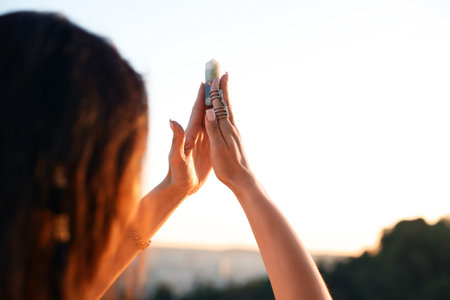Woman meditating with crystal to heal or restore her aura outdoors, closeup. Space for text