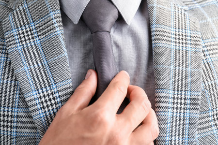 Man in suit adjusting his necktie, closeupの写真素材