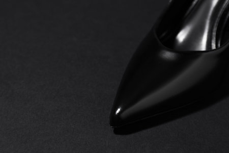 Stylish high heeled shoe on dark background, closeup. Space for textの写真素材