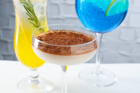 Glasses of tasty cocktails on white table, closeup