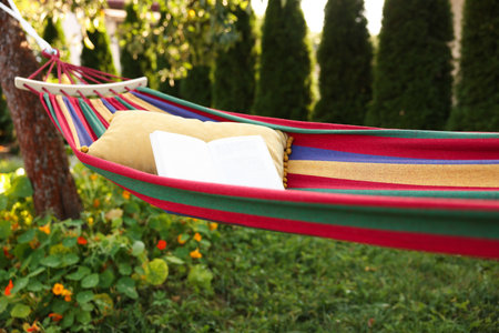 Cushion and book on hammock in garden, closeupの写真素材