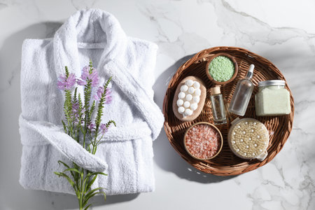 Flat lay composition with bathrobe and spa products on white marble tableの写真素材