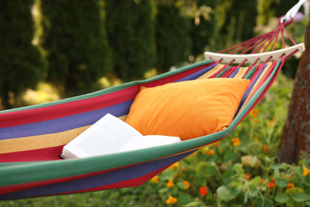 Cushion and book on hammock in garden, closeupの写真素材