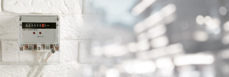 Electricity meter on white brick wall indoors. Banner designの写真素材