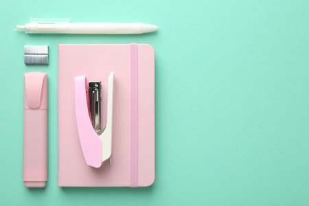 Stapler and other stationery on turquoise background, flat lay. Space for textの写真素材