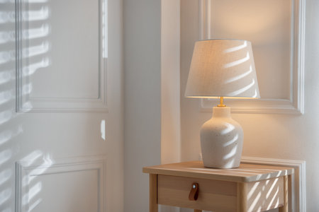 Stylish lamp on nightstand near white wall indoors. Space for textの写真素材